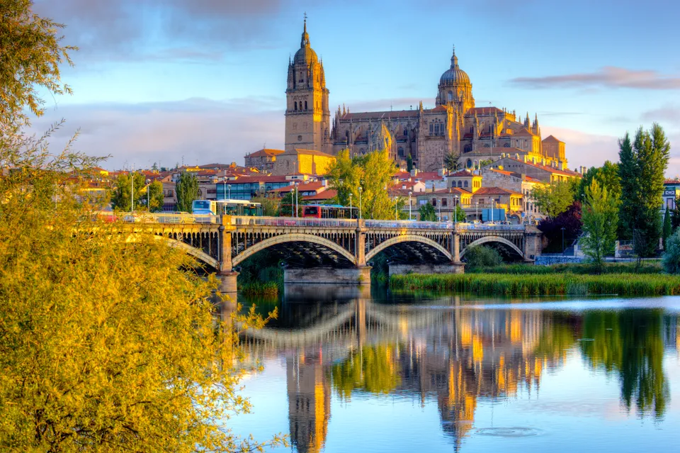 Salamanca’s cathedrals and the Enrique Estevan bridge over the Tormes in morning light.
